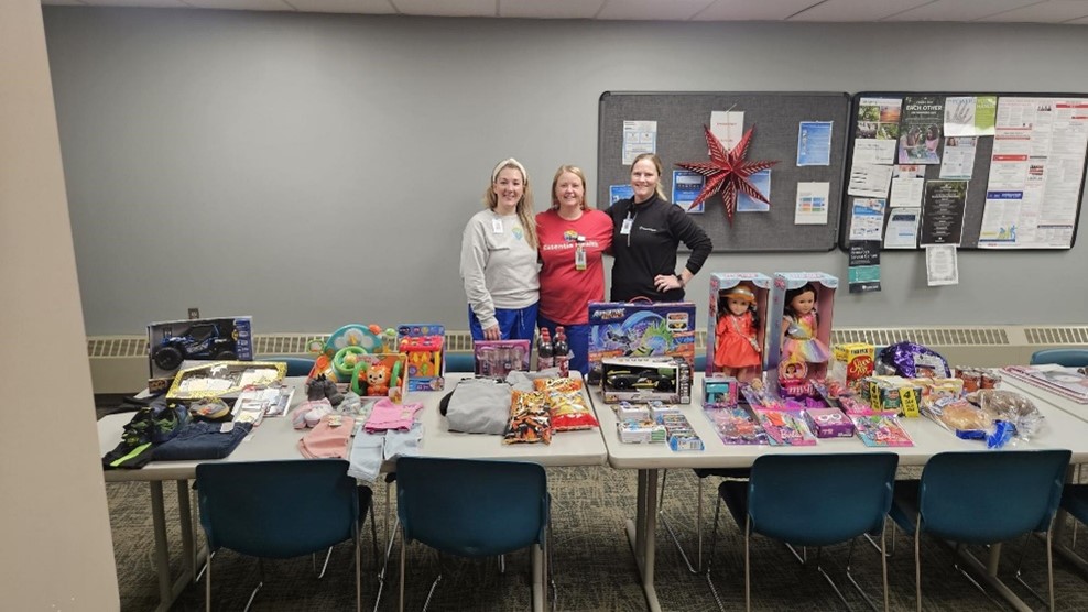 Essentia Employees standing next to donated food