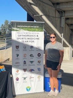 Essentia staff standing by big standing banner