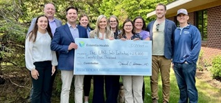 A group holding a big check