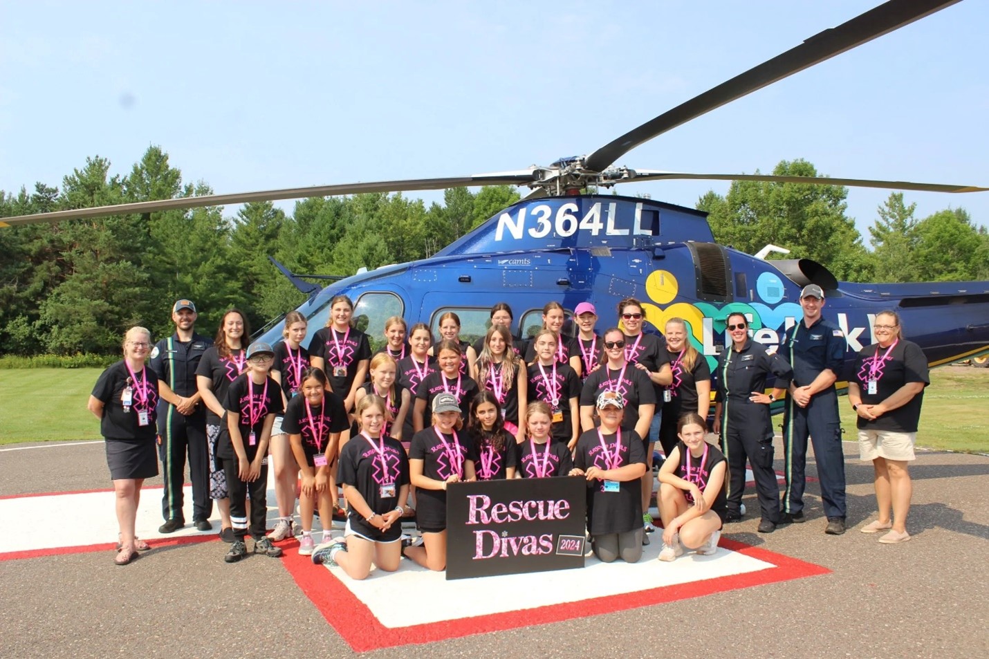 Rescue Divas group stand in front of a helicopter