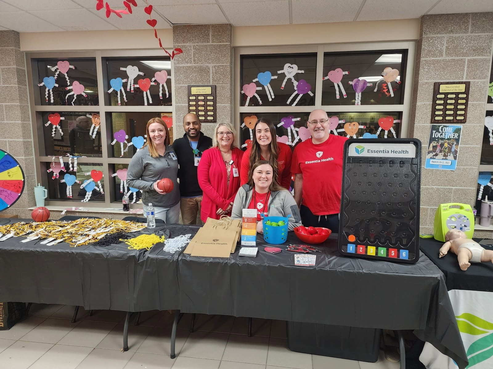 A group behind 2 large desks with items on top